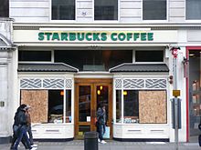 A store on Piccadilly with its windows boarded up after being smashed by protesters Starbucks boarded up after riot.jpg