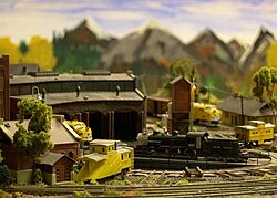 Um diorama completo: com paisagem, estruturas e locomotivas, feito na escala Z.