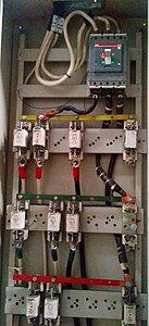Шинопровод тока промышленной частоты и подключённые к нему предохранители в шкафу. Цвета шин соответствуют стандартам СССР.