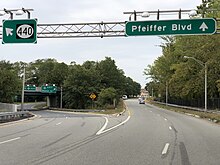 A four-lane road at dusk approaching a large split