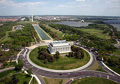 An aerial photo a large white building with big pillars.