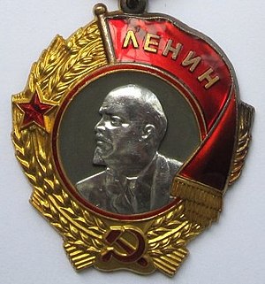 A medal with half of Lenin's face on it, and a hammer and sickle at the bottom with a laurel wreath