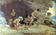 A group of four Neanderthal men, one woman, and her naked son standing on a rock platform with a cave behind them, looking worriedly off to the right. The men are wearing only furs wrapped around their waist, one has a spear, and another is crouching with food in his hand. The woman is standing inside the cave, has a fur pulled up to her collarbone, and is holding her son close