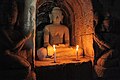 Buddha images flanked by donors sculpted in low relief