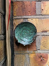 A bronze work by Jonesy on a wall in Brick Lane (London). Diameter about 8 cm. JonesyLondon.jpg