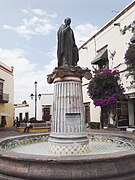 Una fuente en una plaza pública con una estatua de bronce en ella.