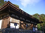 Wooden building on a stone platform with white walls.