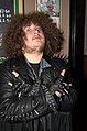 Fanúšik heavy metalu oblečený v súlade s klasickou metalovou módou a ukazujúci gesto „paroháča“.