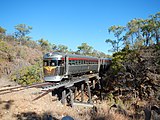 6.–7. KW Der Savannahlander passiert eine alte Holzbrücke auf der Tablelands Line. Er verkehrt zwischen Cairns und Forsayth in Far North Queensland, Australien (2013).