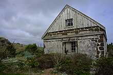 photo of a stone and wood cottage in a rural environment