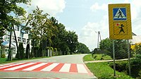 Przykład przejścia dla pieszych w rejonie placówek oświatowych. Poniżej znaku D-6 jest tabliczka T-27 z namalowaną „Agatką” (przejście dla pieszych przy szkole w Stróżach 49°50′14″N 20°46′09″E/49,837222 20,769167)