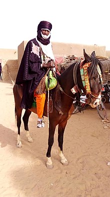 Cavalier portant un turban, sur un cheval richement décoré.