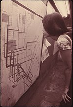 A subway rider examines the subway map as posted on the platform of one of the stations in 1974