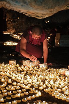 Un bhikshu allumant des lampes de ghi dans une grotte sacrée du plateau tibétain, en juin 2021. (définition réelle 3 439 × 5 158)