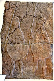 Alabaster-bas relief, non-Assyrian mercenaries in the Assyrian army. From the South-West Palace, Nineveh. 7th century BC Alabaster-bas relief, non-Assyrian mercenaries part of the Assyrian army, holding spears and shields. From the South-West Palace, Nineveh, Iraq. 7th century BCE. Pergamon Museum.jpg