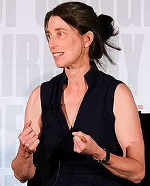 Alexandra Horowitz gesturing in front of a stage background