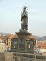 Statua di San Giovanni Nepomuceno, opera di Matthias Rauchmüller del 1683. Fu la prima statua ad essere posta sul ponte. È credenza diffusa che la statua porti fortuna: si suppone che toccando la lapide alla base della statua, che ricorda il punto esatto dell'esecuzione del santo, si riceve fortuna per i successivi 10 anni e viene assicurato il proprio ritorno a Praga