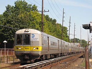 Der Long Island Rail Road Zug Nr. 2820, ein Zug mit acht Wagen auf der Far Rockaway Branch, fährt von der Cedarhurst Station auf dem Weg nach Far Rockaway ab.