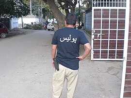 A personnel of the Sindh Police in uniform with a handgun on his belt. Sindh police constable.jpg