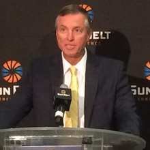 A color photograph of Willie Fritz in a suit speaking at a podium