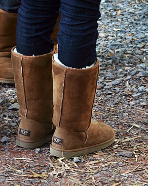 Pair of chestnut Ugg boots with jeans tucked i...
