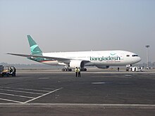 A white aircraft with Bangladesh written in green on the front half below the windows with a dark green colour on the tail facing right