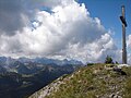 Summit cross on the Demeljoch, with, in the background, the view towards the west.