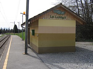 One-story building with gabled roof next to track and platform