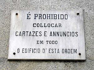 aviso anterior a 1911 na parede da Igreja do Carmo, na cidade do Porto.