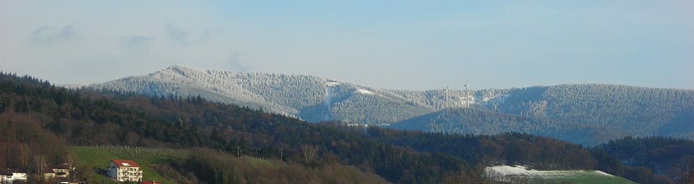 Rigardo de Freiburg al la monto Schauinsland kun la ventoturbinoj sur Holzschlägermatte en marto 2007