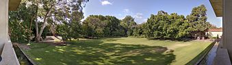 A panorama showing an open grassed area seen from the first floor