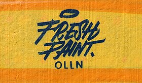 Le logo de Fresh Paint OLLNsur la fresque de la chaussée de la Croix.