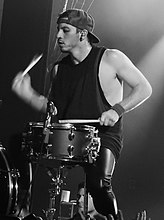 Josh Dun playing drums live for an audience.