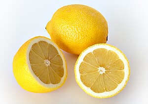 Two lemons, one whole and one sliced in half