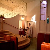 Nun profession ceremony for a new nun, admitted to the cloister (behind the half door). Nun procession ceremony.jpg