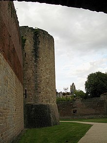 Rempart et tour. En arrière-plan, une église.