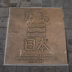 Partnerstadtwappen in der Georgstraße, zeilenweise Inschrift: 広島 (Hiroshima) / Stadtwappen Hiroshimas[135] / 日本 (Japan) / Hiroshima/Japan, Partnerstadt Hanovers / seit 1983