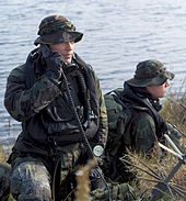 Air Force Combat Controllers make a call to aircraft using their radios after having penetrated a Florida shoreline with tactical underwater breathing equipment during a training event.