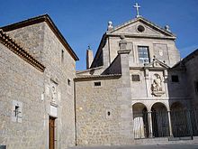 Enceinte de pierre d'un couvent, avec à droite la façade de l'église, de style classique.