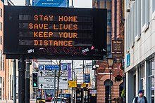 Electronic display sign normally used for traffic management displays COVID-19-related advice on an almost deserted Chichester Street in Belfast City Centre, 24 March 2020. Belfast COVID19 Traffic Management Sign.jpg