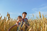 Deux enfants batifolent dans un champ de blé.