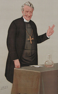 A "Spy" cartoon of a clergyman with greying hair, parted to the right, wearing a black jacket and a large gold pectoral cross, standing behind a table with his left hand raised in blessing