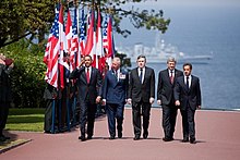 US President Barack Obama, Prince Charles, Brown, Canadian Prime Minister Stephen Harper and French President Nicolas Sarkozy arrive at the Colleville-sur-Mer cemetery to attend a ceremony marking the 65th anniversary of the D-Day landings in Normandy, 6 June 2009. Obama, Prince Charles, Brown, Harper & Sarkozy at Normandy American Cemetery and Memorial 2009-06-06.JPG