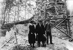 Kommittén för Skogs kyrkoruins framgrävande och konservering år 1928. Från vänster: Fru E. Westerlund, kyrkoherde V. Roland, postmästare J. Kaégatz.