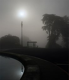 In this photograph, the Sun is visible above the top of the streetlight. In the reflection on the water, the Sun appears in line with the streetlight because the virtual image is formed from a different viewing position. The sun, street light and Parallax edit.jpg