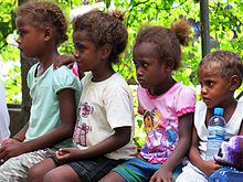 Children in Solomon Islands watch a play on gender-based violence. Young kids watch a play about gender based violence at the Young Women's Christian Association. (10660719084).jpg