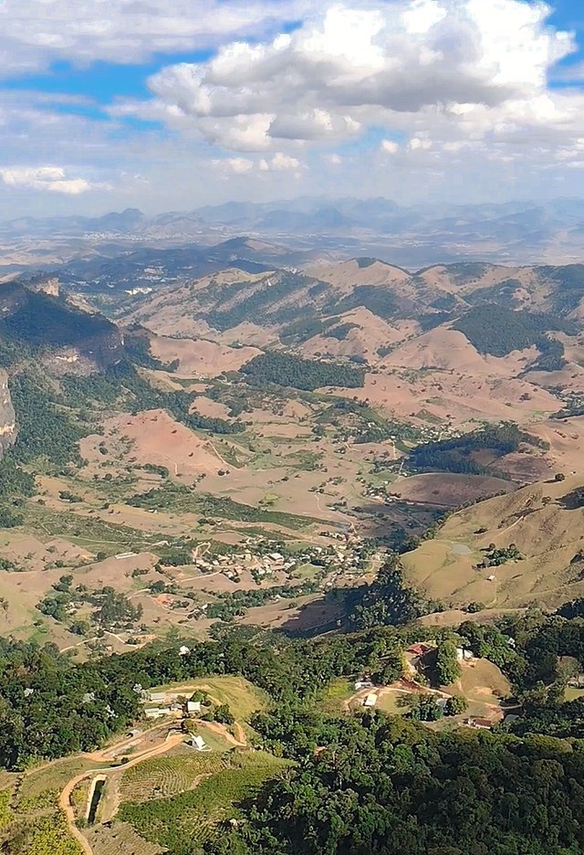 Vista parcial do distrito de São Vicente através da Pedra da Penha. Sede do distrito de São Vicente e a cidade de Cachoeiro de Itapemirim ao fundo