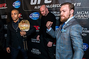 Conor McGregor, Jose Aldo, and Dana White at a press conference for the fight between McGregor and Aldo. This shows the two fighters posing for media, increasing revenue and interest in the fight. Jose Aldo vs. Conor McGregor, UFC 189 World Tour London.jpg