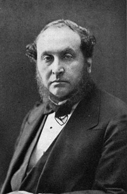 photograph of middle-aged man with bushy sideboards facing spectator, in jacket, waistcoat and bowtie