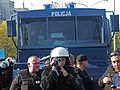 Polish Police's Anti-Riot Detachment, filming a gathering. The film could later be presented during a trial as evidence. A water cannon is seen in the background.